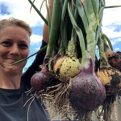 Frieda Bakker holding fresh onion harvest