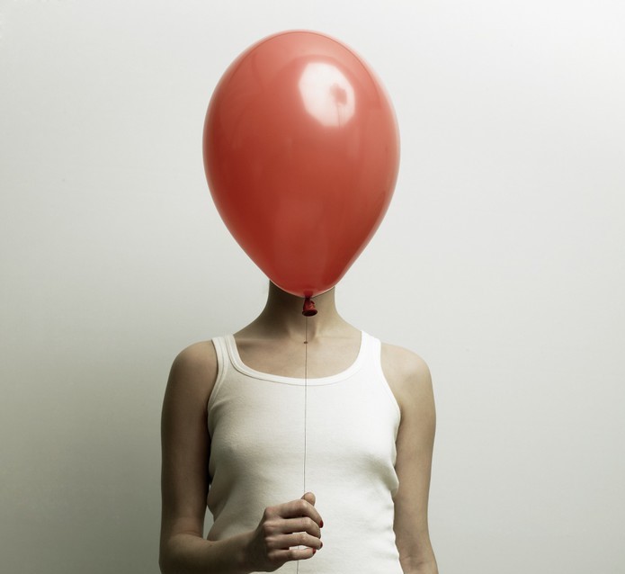 Rode ballon voor hoofd van vrouw